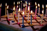 A birthday cake with lit candles.