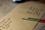 a fountain pen on a brown envelope.