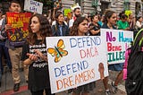 Protesters in San Francisco hold signs with slogans such as “Defend DACA” and “No human being is illegal”.