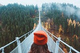 Woman walking on bridge looking ahead.