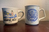 Two coffee cups from Navy Commands.
