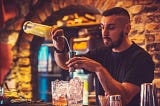 A bartender prepares a mixed drink.