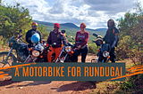 A group of 3 female and one male motorbike riders standing next to their bikes in a bushland in Africa