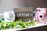 Do Something Creative Everyday on a wood board, includes a camera and mug