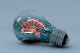 Image of a flower in a background of blue inside of a lightbulb.