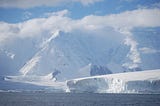 Antartica, cliffs of ice surrounded by sea.