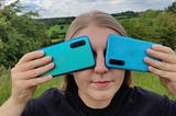 Sophie holding the OnePlus Nords devices over her eyes.