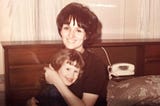 Young woman holding a little girl on her lap 1960's