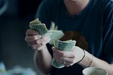 Someone counting out banknotes in their hands