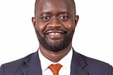 Photo of Von Onyango in suit and tie and smiling