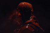 A man drenched in dark-red blood.