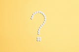 Pills positioned to shape a question mark