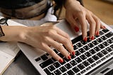 Woman’s hands typing on laptop keyboard