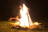 A tall campfire surrounded by stones