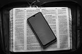 Smartphone placed on opened dictionary in case bag.