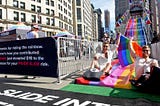 Tinder’s 30-foot rainbow Pride slide has a very serious message.