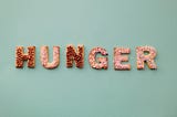 Cookies that are cut into letters and arranged to spell the word “HUNGER”