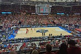 Basketball court in a crowded stadium showing women players