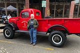 woman stands in front of red truck