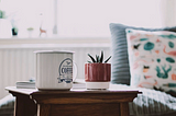 Coffee mug and a plant in a bench to represent us working from home.