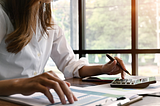 Woman calculating finances at a table.