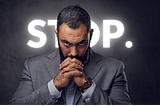 A man looking straight in front of him. Behind him, the text “Stop”.