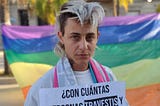 chico trans mostrando un cartel que dice: con cuántas personas trans trabajas?