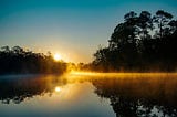 The gleam of last light on a river’s surface a dusk. Source : Unsplash.