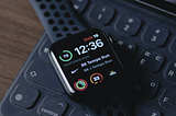 Image depicts a black-grey Apple watch placed over a keyboard. Interface shows stats of the user’s run.