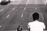 Man and child looking out over a many-laned street.