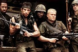 Tropic Thunder movie showing 5 actors dressed as army soldiers. All looking stern at the camera whilst holding weapons.