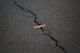 a bandaid over a crack in asphalt