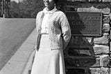 Wilhelmina Reuben, May Queen 1967, leans on a stone column with a plaque that says, “Sarah P. Duke Gardens, Main Entrance.”