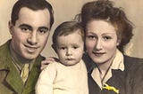 Hand-tinted photograph of an man, child and woman. The man is dressed in military uniform and the woman’s clothing and hair are typical for the 1940s.