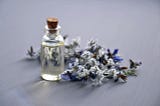 clear glass bottle next to dried blue flowers