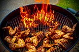 Crispy Chile Oil Wings Roasting on Grill Opposite a Full Fire