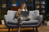 Image of a girl sitting on the sofa and using a laptop with NBN.