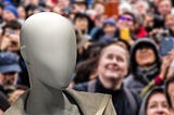 A faceless image in the midst of a crowd of people