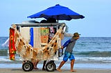 Hawker pulling a cart on the beach