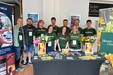 Members of the Bloom & Wild Engineering team standing behind the sponsor booth at the Brighton Ruby conference