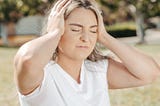 A woman holding her head in pain