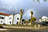 My town’s churchyard with a rainbow in the background agains the stormy dark skies.