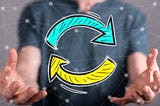 Blurry headless picture of person in a dark t-shirt with their hands open wide. Between their hands there are two colored half circle arrows feeding back into one another, implicating feedback loop and repetition