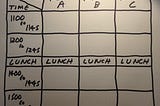 A spreadsheet like grid, with room names on the top row and times down the left hand column. The columns are named Room A, Room B and Room C. The rows are named 1100, 1200, Lunch, 1400 and 1500.