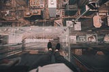 Feet standing on ledge overlooking city.