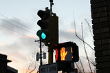 Image shows a lit stoplight that is green for cars, but red for pedestrians.