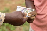 A photo of the hands of two farmers exchanging money