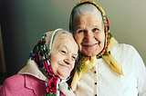 Two grandmas in headscarves smiling