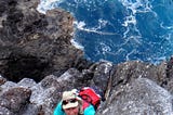 Rachel Rounds ascending rock cliff at Nihoa island