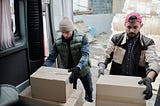 Image of two people loading boxes on a truck